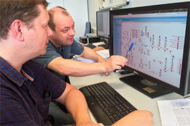 Zwei Wissenschaftler bei der Diskussion über das Alacris-ModCell-Modellierungssystem am Computer