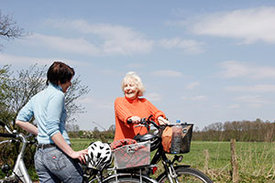 Zwei Frauen mit Fahrrad unterhalten sich.