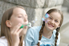Zwei Mädchen lassen Seifenblasen steigen.