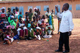 Auf einem Dorfplatz in Burkina Faso informieren sich junge Mütter über die Möglichkeit, gemeinsam mit ihren Kindern an einer klinischen Studie für einen Malaria-Impfstoff teilzunehmen.
